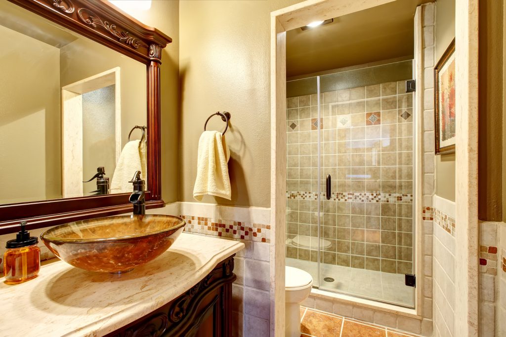 Bathroom interior in luxury house. Rich bathroom vanity cabinet with vessel sink and mirror. View of shower. Northwest USA