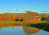 an old barn,in the fall, reflects in the pond in the morning light, repurposed barn materials
