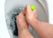 Plumber repairing toilet with a hand plunger.